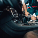 Car wash service worker wet cleaning expensive and luxurious vehicle interior and seats